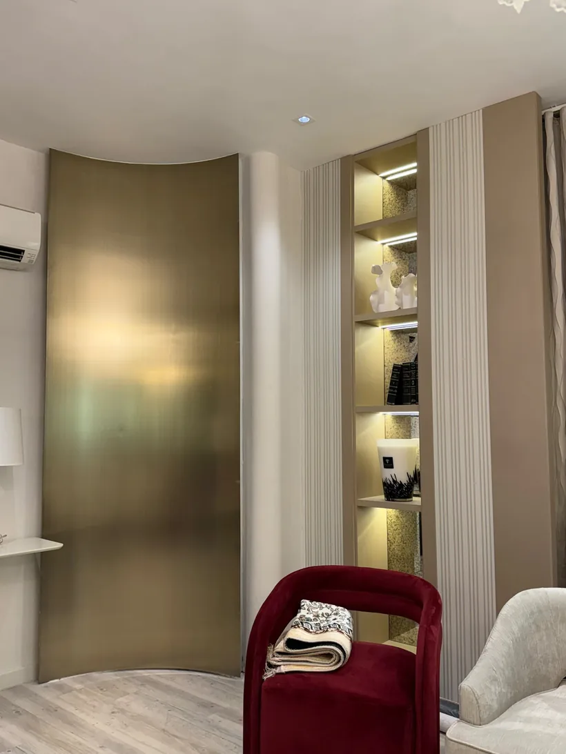 Curved feature wall beside lit display shelving
