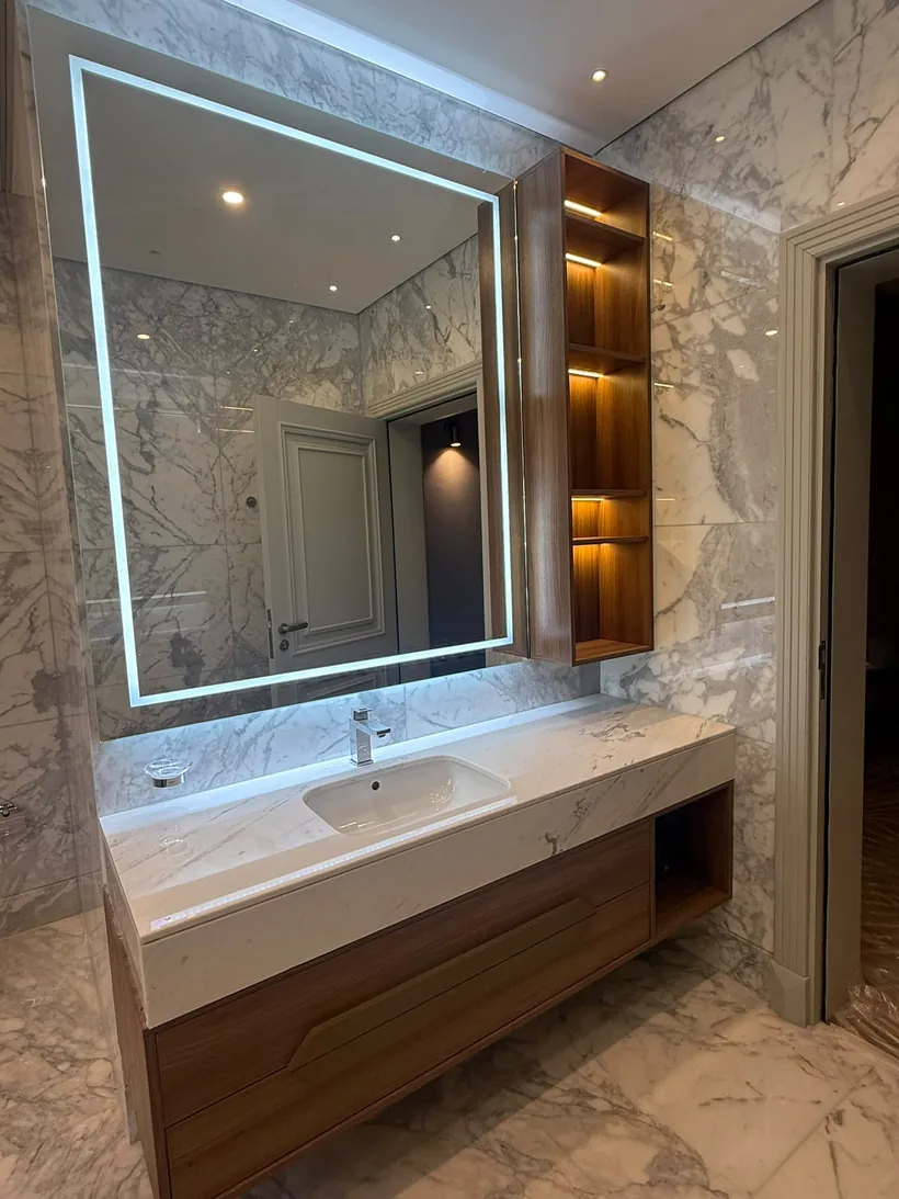 Bathroom vanity in walnut with a lit niche and backlit mirror
